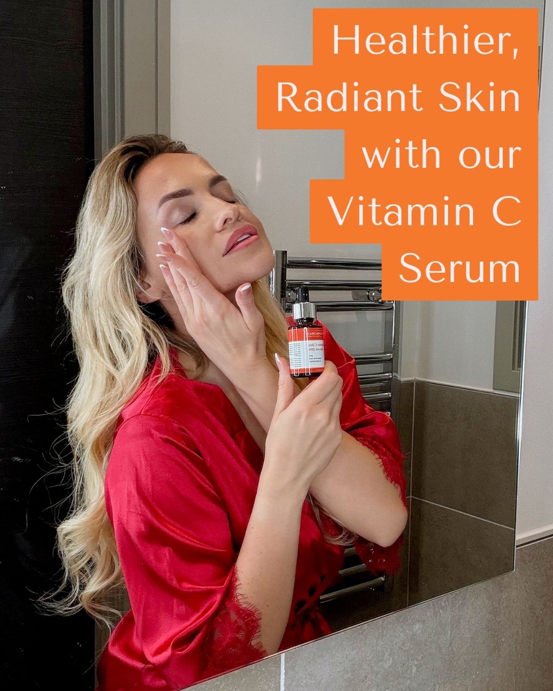 Attractive young blonde woman massages Dermaworks' vitamin c serum for face into her cheeks for anti-wrinkle and skin brightening results.